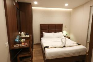 a bedroom with a bed and a table with a plate of food at Fair Stay Hotel in Cochin