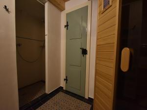a hallway with a green door and a closet at Holiday home in a quiet, authentic mountain village with a view of the surrounding hills in Zlatá Olešnice +8 photos