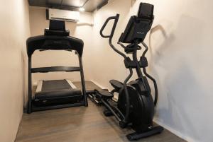 a room with a treadmill and a phone on a wall at Fair Stay Hotel in Cochin
