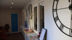 a room with a counter with a clock on the wall at Hotel an der Rennbahn Kostenloses Parken in Dresden +21 photos