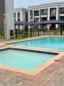 a large swimming pool in front of a building at Cozy Habitat in Gaborone