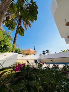 een strand met een parasol en een paar palmbomen bij Farah Boutique Private Villa in Luxor +33 foto's
