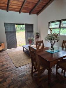 a dining room with a wooden table and chairs at The Macadamia Nut Farm House in White River