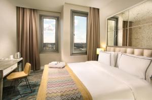 a hotel room with a bed and a desk and two windows at Berjer Boutique Hotel & Spa in Istanbul