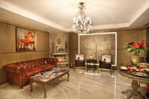 a living room with a leather couch and a chandelier at Berjer Boutique Hotel & Spa in Istanbul