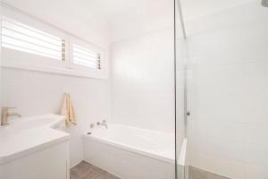 a white bathroom with a tub and a sink at Dalton Escape in Nelson Bay +22 photos