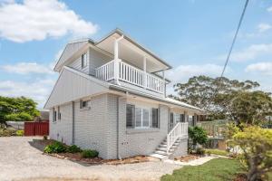 a white house with a staircase in front of it at Dalton Escape in Nelson Bay
