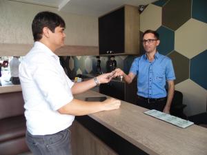 dos hombres parados en un mostrador en una cocina en Juazeiro Residence Hotel, en Juazeiro do Norte