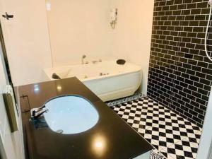 a bathroom with a tub and a sink with a mirror at เคทูกรีน สุพรรณบุรี in Ban Hua Phrong +5 photos