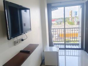 a flat screen tv hanging on a wall next to a window at เคทูกรีน สุพรรณบุรี in Ban Hua Phrong
