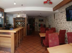 ein Restaurant mit Tischen und roten Stühlen und einer Bar in der Unterkunft Palais Cathare in Bélesta