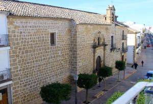 un gran edificio de ladrillo con árboles delante de él en La Muralla, en Sabiote