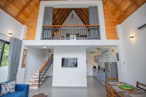 a living room with white walls and a wooden ceiling at Gone4Coastal - Cabana in Hikkaduwa