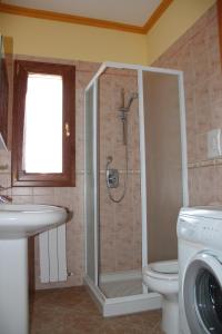 uma casa de banho com um chuveiro, um WC e um lavatório. em Attico em Cefalù