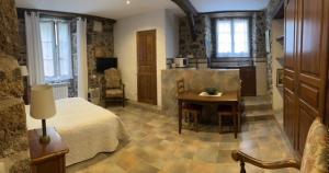 a bedroom with a bed and a table and a kitchen at Etxezuria in Valcarlos