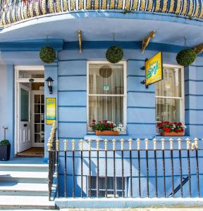 a blue house with flowers in the window at Brighton Surf Guest House in Brighton & Hove