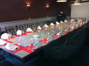 a long table with red napkins and glasses on it at Le Beverl'inn in Flers
