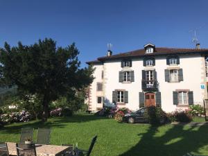 a large white house with a car parked in the yard at Etxezuria in Valcarlos