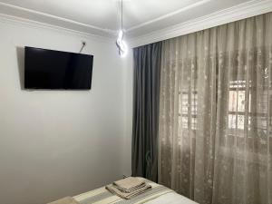 a bedroom with a tv on the wall next to a window at Bulevard Residence in Drobeta-Turnu Severin
