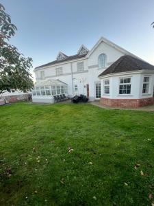 a large white house with a large yard at Family & friends get together birthday hot tub in Porthcawl