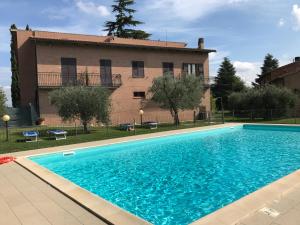 a swimming pool in front of a house at Agriturismo Azienda Agricola La Roccaia in San Gimignano