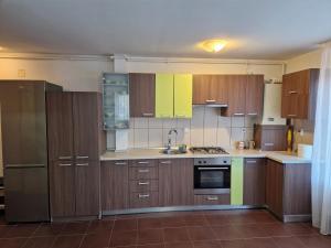 een grote keuken met houten kasten en apparaten bij COM Home Floresti in Floreşti