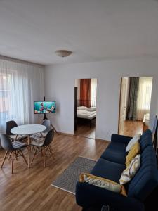 een woonkamer met een blauwe bank en een tafel bij COM Home Floresti in Floreşti