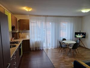 een keuken met een tafel en een kleine tafel en stoelen bij COM Home Floresti in Floreşti +2 foto's