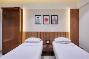 two beds in a small room with twoermottermottermott at Hotel Karl Residency in Mumbai