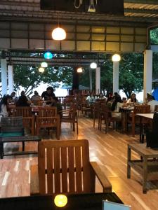 a restaurant with people sitting at tables and chairs at MP Resort Koh Phayam in Ko Phayam