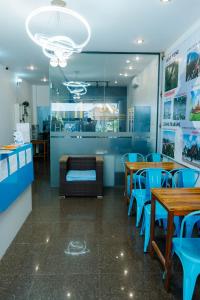 a restaurant with wooden tables and blue chairs at Happy Home Hostel 1 in Vientiane