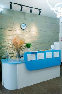 a blue counter with a clock on a wall at Happy Home Hostel 1 in Vientiane