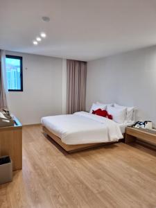 una camera da letto con un grande letto bianco e una finestra di 마산 쉬자호텔 a Masan Altre 4 foto