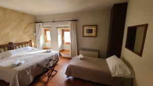 een slaapkamer met twee bedden en een raam bij Hotel Convento San Roque in Balmaseda