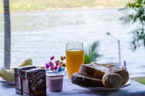 une table avec une assiette de pain et un verre de bière dans l'établissement Pousada Portal do Sol, à Abraão