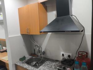 a kitchen with a sink and a black hood at Chandigarh city centre in Zirakpur +4 photos