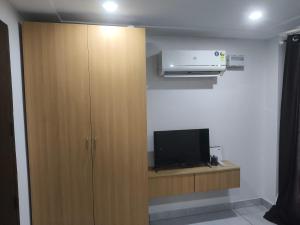 a room with a wooden cabinet and a tv at Chandigarh city centre in Zirakpur