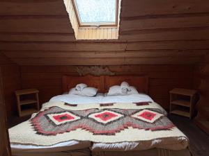 una camera con un letto in una baita di tronchi di Guesthouse Karpaty a Yasinia