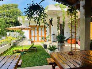 an outdoor patio with wooden tables and plants at Sunset Bay in Dickwella +24 photos