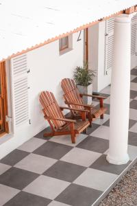 two chairs on a porch with a checkered floor at Palm La Vie in Worcester