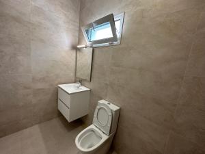 a bathroom with a toilet and a sink and a window at Heritage Community in Brufut +15 photos