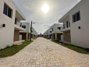 a cobblestone street in front of some apartment buildings at Heritage Community in Brufut