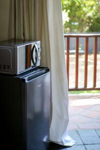 a microwave on top of a refrigerator next to a porch at Palm La Vie in Worcester