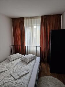 een slaapkamer met een bed met handdoeken erop bij COM Home Floresti in Floreşti