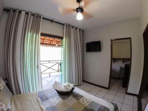 ein Schlafzimmer mit einem Bett und einem großen Fenster in der Unterkunft Pousada Portal do Sol in Abraão