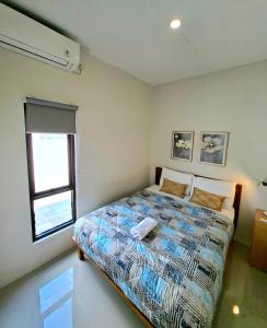 een slaapkamer met een bed en een raam bij Tio Homestay in Praya