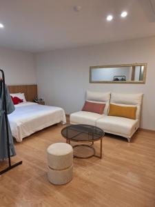 una camera da letto con un letto, un divano e un tavolo di 마산 쉬자호텔 a Masan