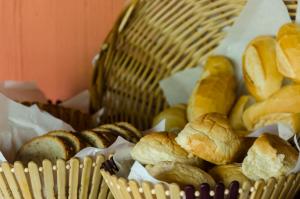 una cesta llena de diferentes tipos de pan en Pousada Portal do Sol en Ilha Grande