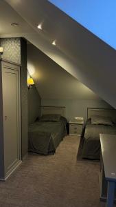 una camera mansardata con 2 letti e una scala di Senoji Hansa Hotel a Palanga