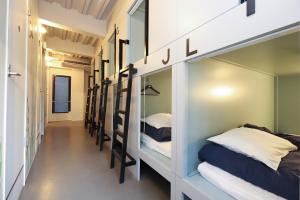 a hallway with a row of bunk beds at E10 Hostel in Tokyo